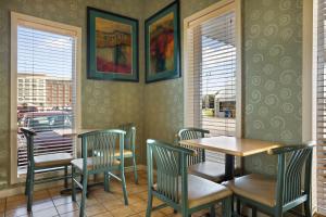 Super 8 by Wyndham Mount Vernon, IL في جبل فيرنون: غرفة طعام مع طاولات وكراسي ونوافذ