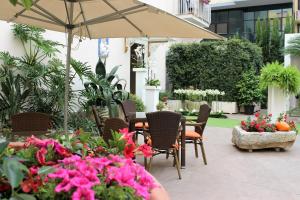 un patio al aire libre con mesas, sillas y flores en Liddo Boutique hotel, en Barletta