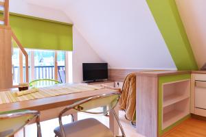 une salle à manger avec des murs verts, une table et des chaises dans l'établissement Apartment Bohinjko, à Bohinj