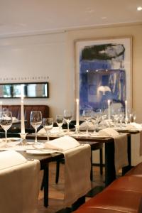 un comedor con una mesa larga con copas de vino en Hotel Kaiserhof en Siegburg