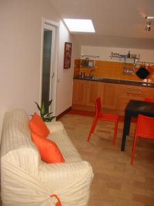 オルヴィエートにあるAppartamento Arancioのリビングルーム(白いソファ付)、キッチンが備わります。