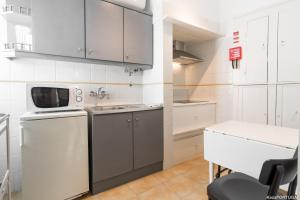 una piccola cucina con lavandino e forno a microonde di Casa Sanches a Cascais