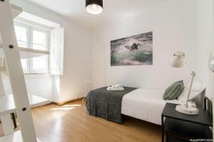 a white bedroom with a bed and a lamp at Casa Sanches in Cascais