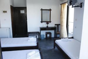 ein Zimmer mit zwei Betten, einem Spiegel und einem Tisch in der Unterkunft Elvira Hotel in Stalida