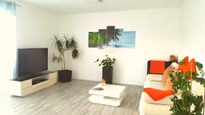 a living room with a couch and a flat screen tv at Moderne Neubau Ferienwohnung in Kassel