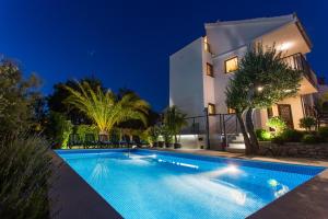 a villa with a swimming pool at night at Villa LeANN in Okrug Donji