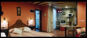 a bedroom with a large bed and a stone wall at La Llobera Apartamentos in Pendueles