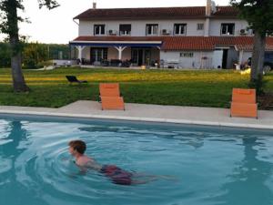 a young boy swimming in a swimming pool at AUBERGE LE GABACHOU in Montpezat-de-Quercy