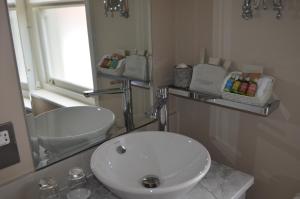 a bathroom with a white sink and a mirror at Castle House Hotel in Hereford