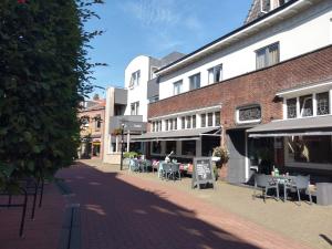 a street with tables and chairs and buildings at Hotel Villa Flora in Hillegom