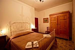 sypialnia z dużym łóżkiem i drewnianą szafką w obiekcie Affittacamere La Casa Di Elide w Arezzo