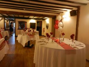 a group of tables with white table cloths and balloons at The Hawkenbury in Staplehurst