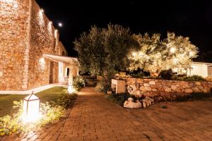 a brick walkway in front of a building with lights at Montiro' Hotel in Leuca