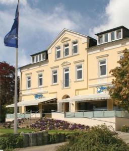 ein großes Gebäude mit einer Flagge davor in der Unterkunft Hotel Kieler Förde in Kiel