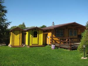 een geel huis in een tuin met een hek bij Kolkja Holiday Centre in Kolkja