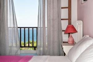 a bedroom with a bed with a view of the ocean at Zefiros in Agios Ioannis Pelio