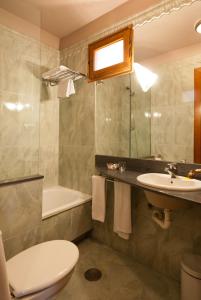 a bathroom with a toilet and a sink and a tub at Hotel Vetusta in Oviedo