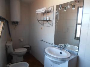 łazienka z toaletą i umywalką w obiekcie Hotel Alfar w mieście Isla
