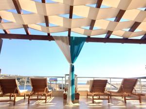 un grupo de sillas en el techo de un edificio en Vila Kosteli, en Himare