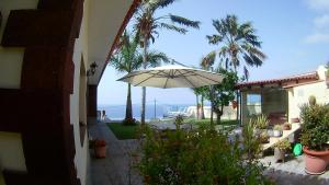 a patio with an umbrella and a view of the ocean at Villa Necho in La Orotava