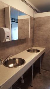 uma casa de banho com 2 lavatórios e um espelho em Motell Trafikanten em Bygdeå