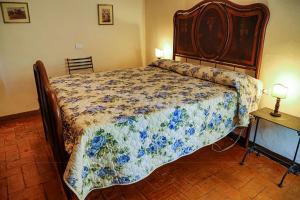 a bedroom with a bed with a floral bedspread at Frascole in Dicomano