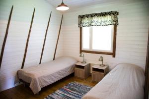 two beds in a room with a window at Rauhanlaakson Jokimökit in Merikarvia