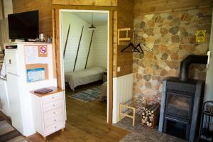 Zimmer mit einem Holzofen und einem Schlafzimmer in der Unterkunft Rauhanlaakson Jokimökit in Merikarvia