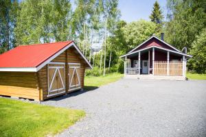 ein kleines Gebäude mit rotem Dach und einer Garage in der Unterkunft Rauhanlaakson Jokimökit in Merikarvia