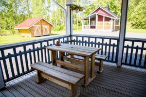 a picnic table and a bench on a porch at Rauhanlaakson Jokimökit in Merikarvia