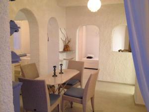 a dining room with a table and chairs and a bedroom at Kyano House in Limenas