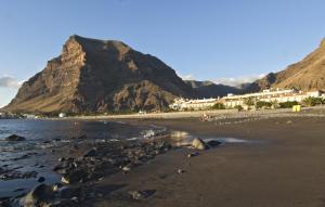 a beach with a mountain in the background at Hotel Gran Rey in Valle Gran Rey