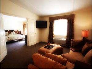 a living room with a couch and a bed at Inn at Arbor Ridge Hotel and Conference Center in Hopewell Junction