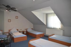 a room with three beds and a window at Motel Eden in Zamość