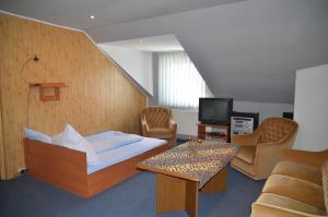 a hotel room with a bed and a couch and a tv at Motel Eden in Zamość