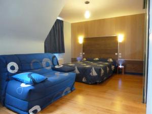 a living room with a blue couch and a bed at BreizH HoteL in Crach