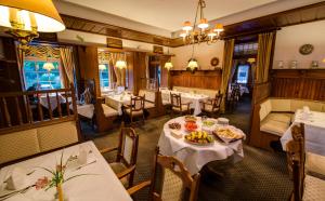 a restaurant with tables and chairs and a plate of food at Hotel Fährhaus Ziehl in Geesthacht