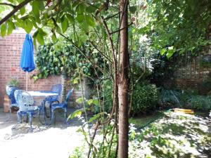 a table and chairs in a garden with an umbrella at The Poop Deck in Upton upon Severn