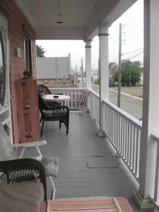 a porch with chairs and a table on a house at Maison McKenzie House in Campbellton