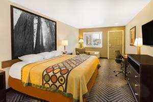 a hotel room with a large bed and a desk at Super 8 by Wyndham Fortuna in Fortuna