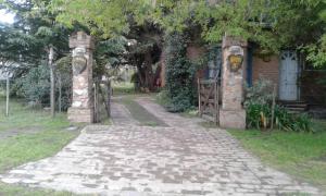 a stone path leading to a house with a gate at Cabañas Ailen in Sierra de la Ventana +2 photos