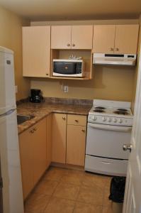 a kitchen with a white stove and a microwave at Linda Vista Motel in Surrey