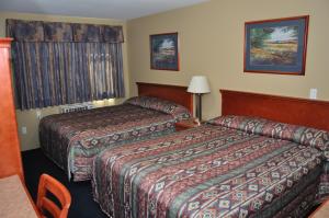 a hotel room with two beds and a table at Linda Vista Motel in Surrey