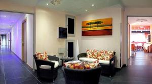 uma sala de estar com sofás e cadeiras e uma mesa em Hotel Savoia em Lignano Sabbiadoro