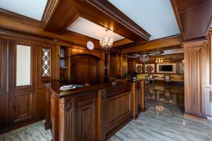a kitchen with wooden cabinets and a clock on the wall at Marina Bay Beach Mamaia Nord in Mamaia Sat/Năvodari