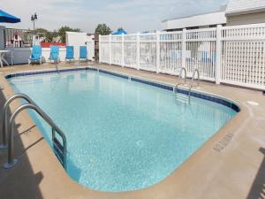 - une piscine dans un complexe avec des chaises bleues dans l'établissement Atlantis Inn, à Rehoboth Beach