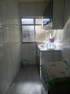baño pequeño con lavabo y ventana en Suítes Praia, en Arraial do Cabo