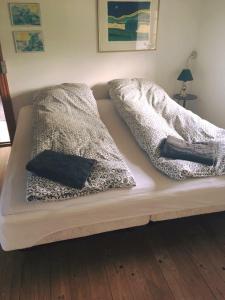 een bed met twee dekens en kussens erop bij Øster Mogensbæk #4 in Sindal
