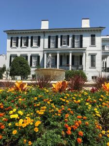 a white house with a flower garden in front of it at Nottoway Plantation and Resort in White Castle