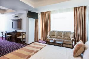 a hotel room with a bed and a couch and a desk at Marina Bay Beach Mamaia Nord in Mamaia Sat/Năvodari